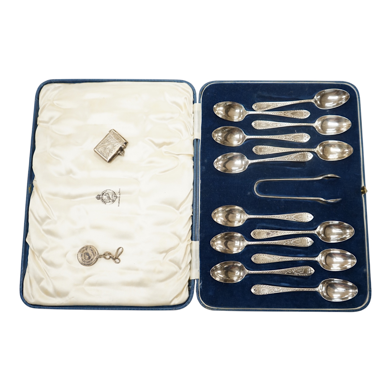 A cased set of twelve late Victorian silver bright cut engraved teaspoons and tongs, by Josiah Williams & Co, London, 1898, together with a silver locket and vesta case. Condition - fair to good